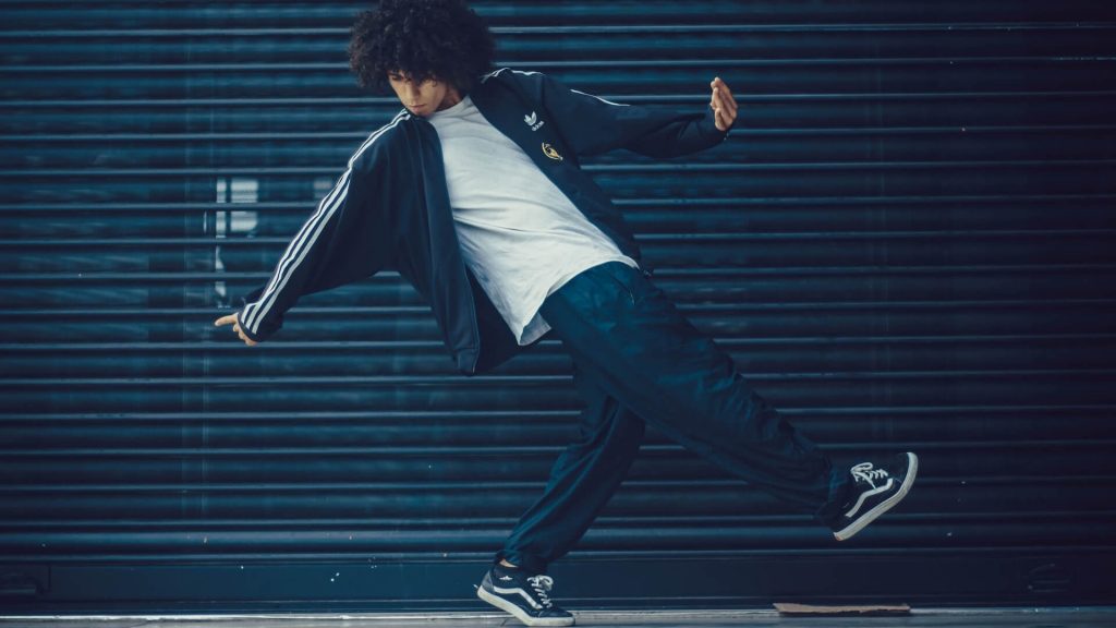 A male dancer wearing a track suit, showcasing his unique style and passion for dance.