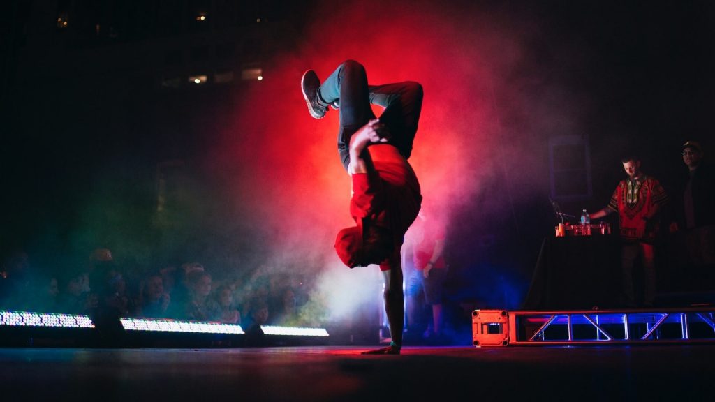 A dancer in a hip hop style performance, displaying energetic and expressive moves.